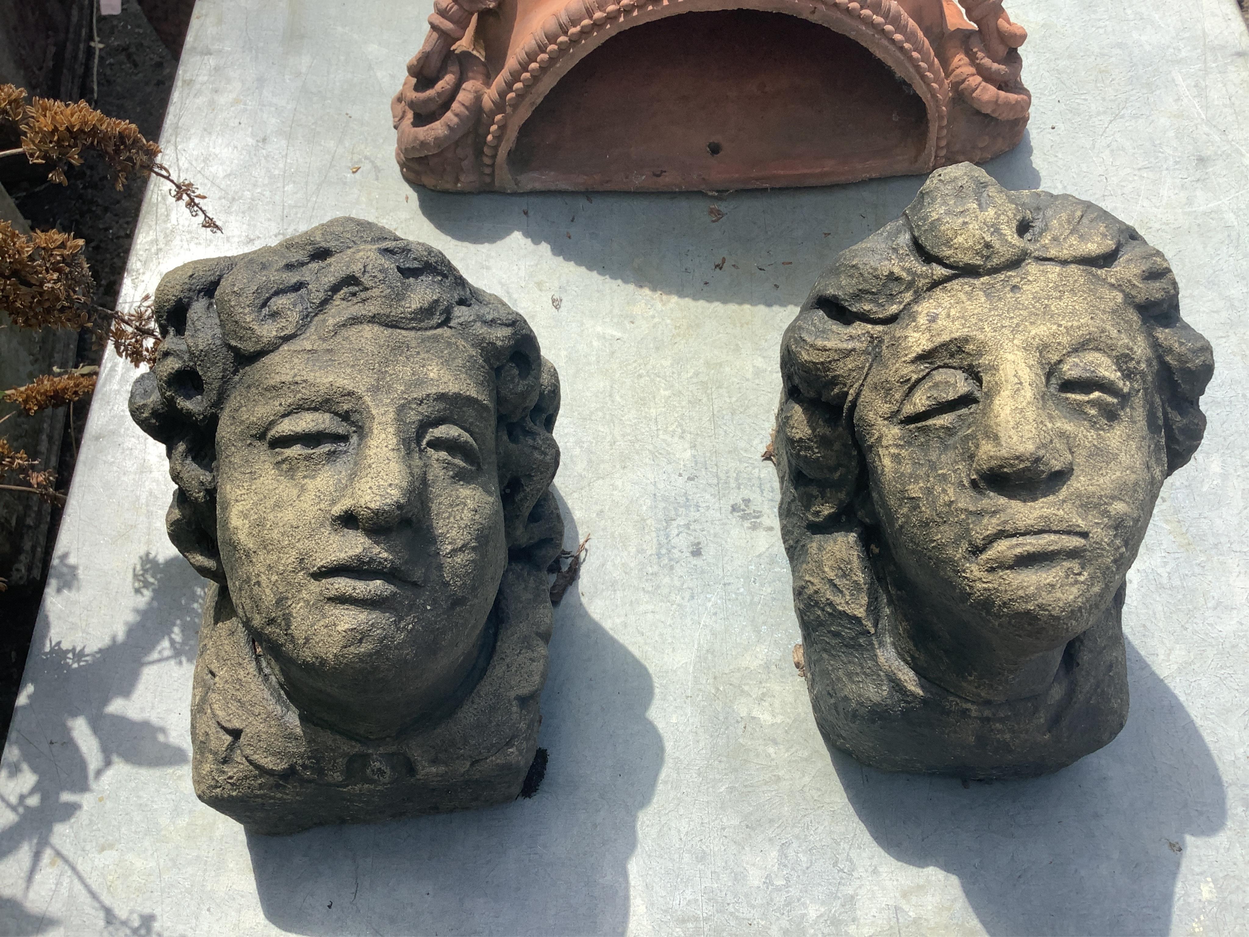 A pair of cast stone mask corbels, height 21cm